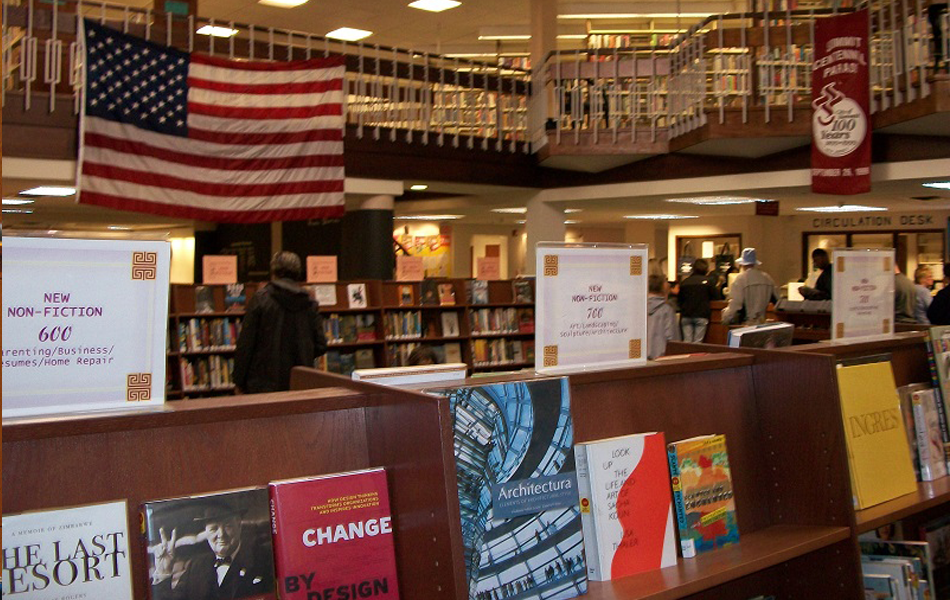 A library with books, shelves, and people